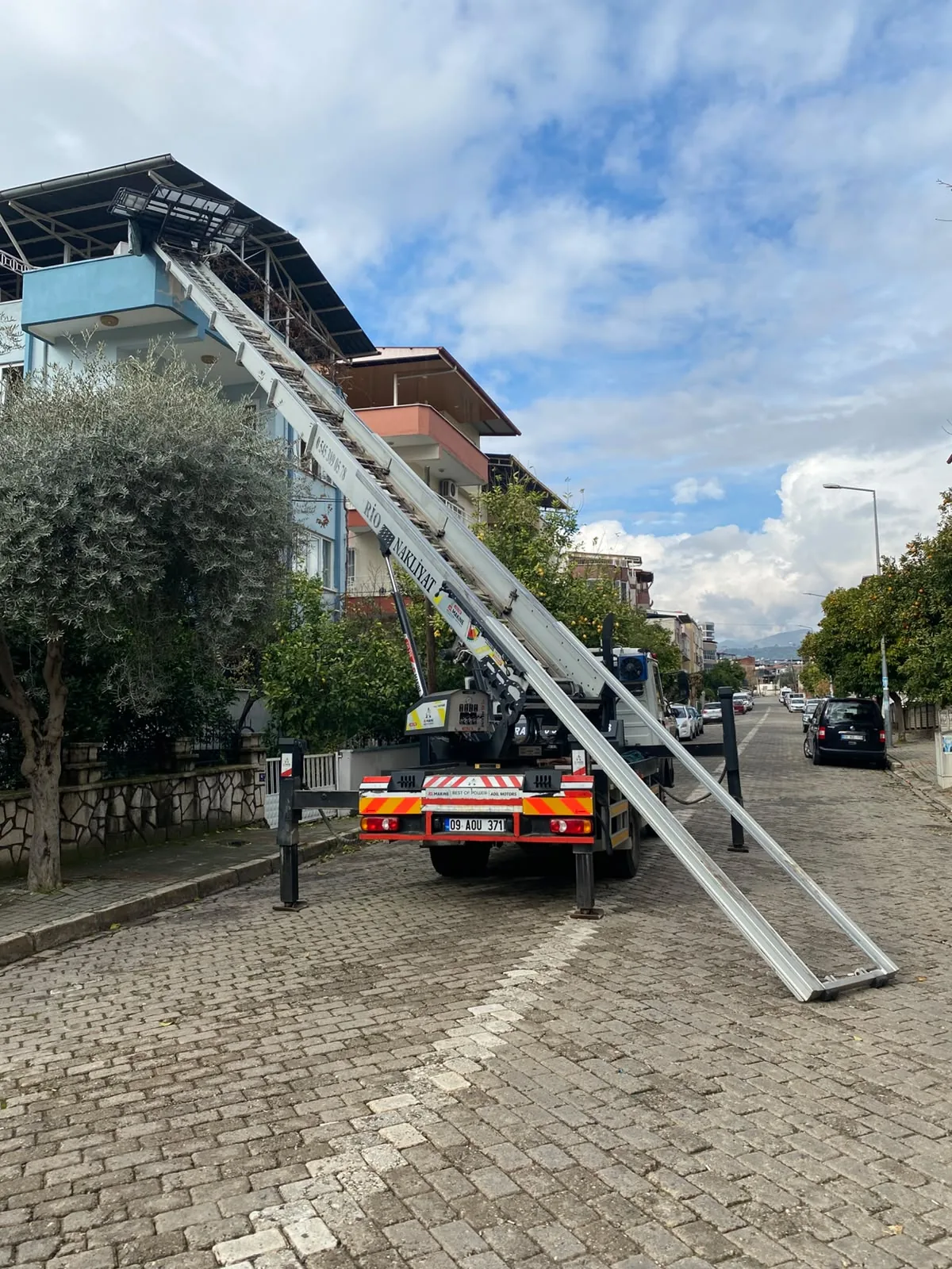 Nazilli Asansörlü Nakliyat Nazilli asansörlü nakliyat aracı apartman cephesine kurulu şekilde taşıma yapıyor